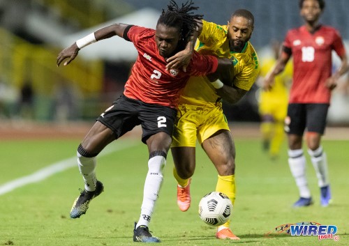 Guyana forward Tyrel Ondaan (right) presses Trinidad and Tobago defender Aubrey David during an exhibition match at the Hasely Crawford Stadium on 29 March 2022. (Copyright Daniel Prentice/ Wired868)