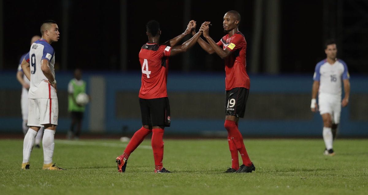Trinidad and Tobago's Kevan George, center right, and Kevon Villaroel celebrate as the U.S.'s Bobby Wood, left, looks on after their World Cup qualifying match at Ato Boldon Stadium in Couva, Trinidad and Tobago, Tuesday, Oct. 10, 2017. (AP Photo/Rebecca Blackwell) — with Kev Villaroel and Kevan George at Ato Boldon Stadium.