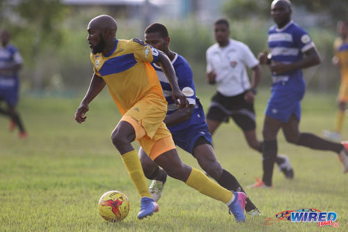 Photo: FC Santa Rosa captain Keron Clarke (left) looks to escape from a WASA FC opponent during TTSL One action in St Joseph on 9 July 2017. Clarke scored twice as Rosa won 3-0. ...(Courtesy Chevaughn Christopher/Wired868)