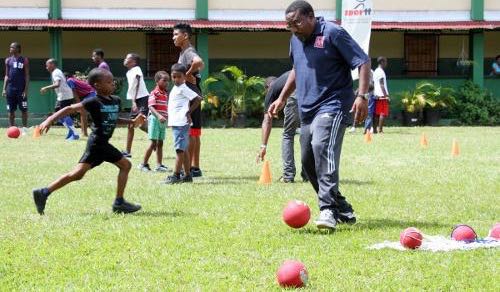 Photo: Former Trinidad and Tobago co-head coach and Morvant Caledonia United co-founder Jamaal Shabazz (right) helps out at a SPORTT Company Easter Camp in 2013. (Courtesy SPORTT Company)