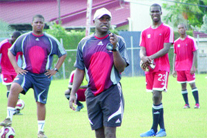 EVE IN CONTROL: National Under-23 football team coach Angus Eve, centre, takes control during a national team training session last month at the Hasely Crawford Stadium training ground. In the background are assistant coach Derek King, left, and Olympic team striker Jamal Gay. –Photo: Ian Prescot