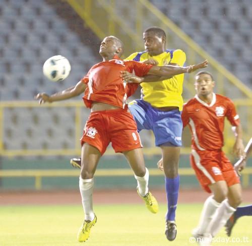 HECTOR SAM of Rangers (light) is challenged for the ball by Defence Force defender Devin Jordan while Sam's team-mate Devon Modeste, right, looks on during action between the teams at the TT Pro League on Friday at the Hasely Crawford Stadium. Defence Force won the game 2-1. ...Author: ROGER JACOB