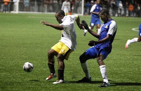 Dandy Town striker Raymond Beach shields the ball from a Defence Force player during last night’s game at BAA Field.