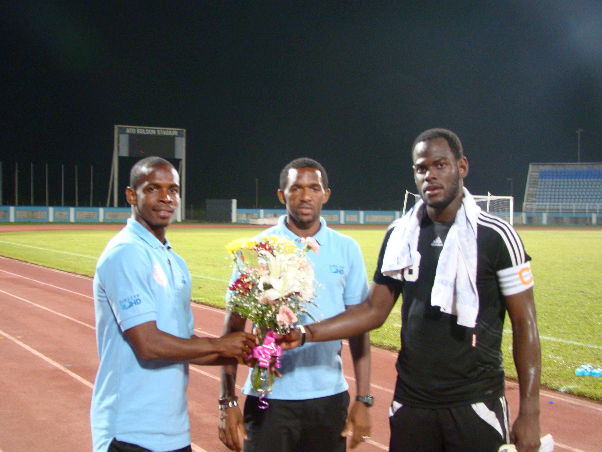 Lto R Antony Wolfe and Charles Pollard of North East Stars present Jan-Michael Williams with a bouquet for his fiancee, Candice Worrell. 