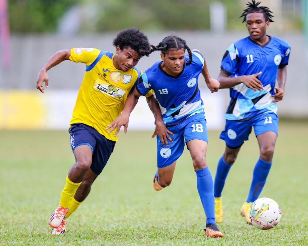 Malick’s Keston Singh (C) wins the duel for possession against Speyside’s Omar Daniel (L) during the Secondary School Football League premiership match at the St Mary’s College grounds on September 23, in Port of Spain. PHOTO BY: Daniel Prentice