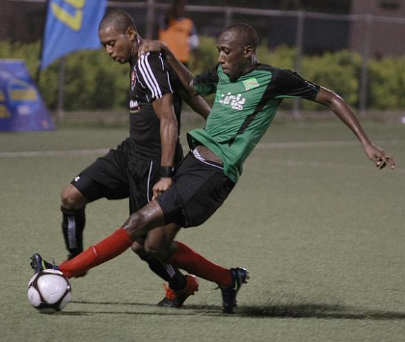 Ma Pau’s Lester Peltier, left, and San Juan Jabloteh’s Noel Williams battle for the ball during quarterfinal C of the Lucozade Sport Goal Shield at the Marvin Lee Stadium, Macoya, Saturday night. Jabloteh won 4-2 on penalty kicks after the score was 1-1 at the end of regulation. Photo Anthony Harris