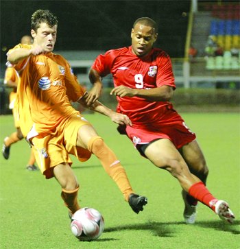 Puerto Rico Islanders’ Scott Jones, left, attempts to elude bmobile Joe Public midfielder Conrad Smith in their Caribbean Football Union Club Champions Cup Final Round match at the Marvin Lee Stadium, Macoya, on Friday night. The match ended 1-1. ...Photo: Anthony Harris