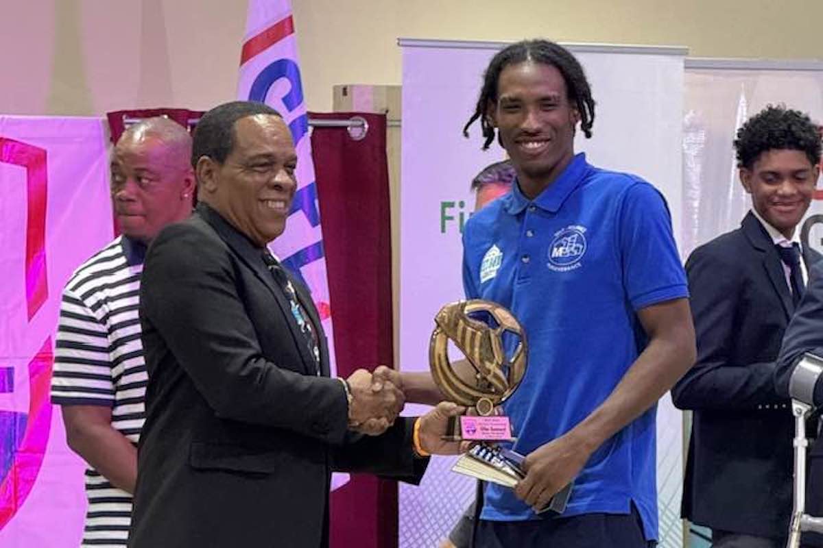 Malick Secondary School's Oba Samuel (right) receives the 2023 SSFL Golden Boot Award from SSFL president Merere Gonzales (left) at the awards and prize giving distribution held at the Chamber of Commerce Building, Couva on Thursday, April 18th 2024.