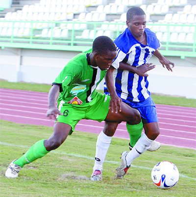 Randell Scott, left, of San Juan North, puts in a tackle on Dexter Perouse of Arima North, during their Coca Cola Secondary Schools Football League (SSFL) Zonal Intercol semifinal match at the Larry Gomes Stadium, Malabar, yesterday. Arima won 4-2. Photo: Angelo Marcelle