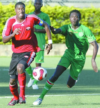 T&T Under-20 captain, Sheldon Bateau, left, and Suriname’s Olvido Misidjang chase after a loose ball in their Caribbean Football Union Group D Under-20 qualifiers at the Marvin Lee Stadium, Macoya, yesterday. T&T won 2–1 to advance to the Concacaf Under-20 12-team Championship in Guatemala next April. ....Photo: Anthony Harris.