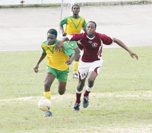 Shackiel Henry, left, of St Benedict's College and Mackel Alexander of Siparia Secondary School sprint for the ball yesterday in the Coca Cola Intercol match at Skinner Park, San Fernando. ...Author: ANIL RAMPERSAD.