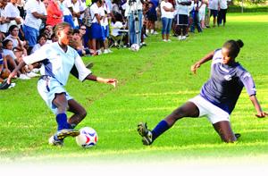 CHAMPIONS: St Joseph's Convent player Kadeisha Sylvester, right, commits herself to a tackle against Providence Girls' goal-scorer Akeisha De la Rosa during the North/East Zone BG T&T InterCol final at St Joseph's Convent Ground, Port of Spain yesterday. De la Rosa scored twice as Providence won 5-3. -Photo: CURTIS CHASE