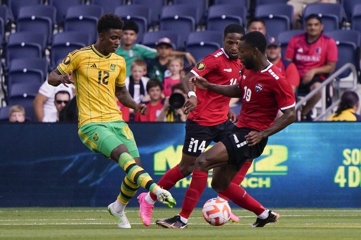 MAKING A CHALLENGE: Trinidad and Tobago striker Malcolm Shaw, right, tackles Jamaican striker Demarai Gray, while T&T left-back Shannon Gomez lurks in the middle. Everton winger Gray netted twice as Jamaica defeated T&T 4-1 in a 2023 CONCACAF Gold Cup Group A preliminary round match Wednesday June 28th 2023, at City Park in St Louis, Missouri, USA.