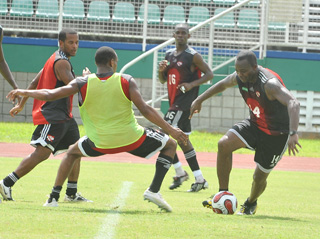 ON THE BALL: Trinidad and Tobago record goal-scorer Stern John, right, tries to get past midfielder Densill Theobald, second from left, while Hayden Tinto, left, and Anthony Wolfe look on yesterday during a training session at the Mannie Ramjohn Stadium, Marabella. T&T are preparing for Sunday's friendly international against India at the Hasely Crawford Stadium, Port of Spain. –Photo: DEXTER PHILIP