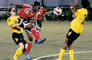 CARIBBEAN CHAMPS: Trinidad and Tobago's Karissa Rodney, second from left, shoots to goal during yesterday's Caribbean Under-20 Women's Football Championship final round tournament clash with Jamaica, at the Marvin Lee Stadium in Macoya. The game ended in a 1-1 draw, and T&T won the title on goal difference. Rodney netted the T&T goal. -Photo: Stephen Doobay.