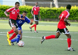 Williams chased: Trinidad & Tobago midfielder Jomas Williams, left, carries the ball under pressure from Cuba's Lezaro Collado. The teams met in a CFU Under-17 Boys qualifying tournament for the 2011 FIFA Under-17 World Cup yesterday at the Marvin Lee Stadium, Macoya. —Photo: Stephen Doobay.