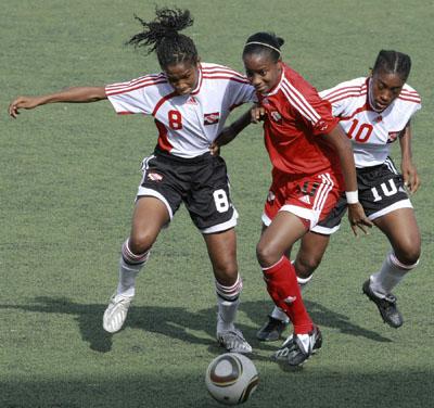 U-17 players, Victoria Swift (left) and Jo-Marie Lewis, try to take the ball away from senior team winger, Tasha St Louis (centre) during a clash between the two national sides at the Marvin Lee Stadium, Macoya last Wednesday. The senior women won the match 2-1. Photo: Anthony Harris