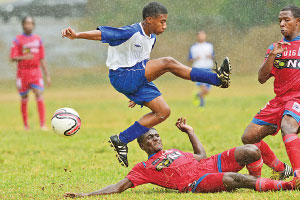 Challenged: Defence Force midfielder Justin Brooks hurdles a tackle from St AnnÂ’s RangersÂ’ Travell Edwards during their Youth Pro League Under-16 encounter at Trinity College Ground, Moka, Maraval on Sunday. Rangers won the high scoring match 5-3. Â—Photo: ROBERT TAYLOR