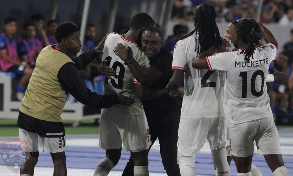 Coach Angus Eve, centre, hugs Malcolm Shaw (No 19) as they celebrate with Nathaniel James from left, Aubrey David (No 2) and Duane Muckette (No 10) after Shaw scored T&T's second goal against El Salvador in their second game of the CONCACAF Nations League on Sunday in San Salvador, El Salvador. T&T won 3-2. ...TTFA Media