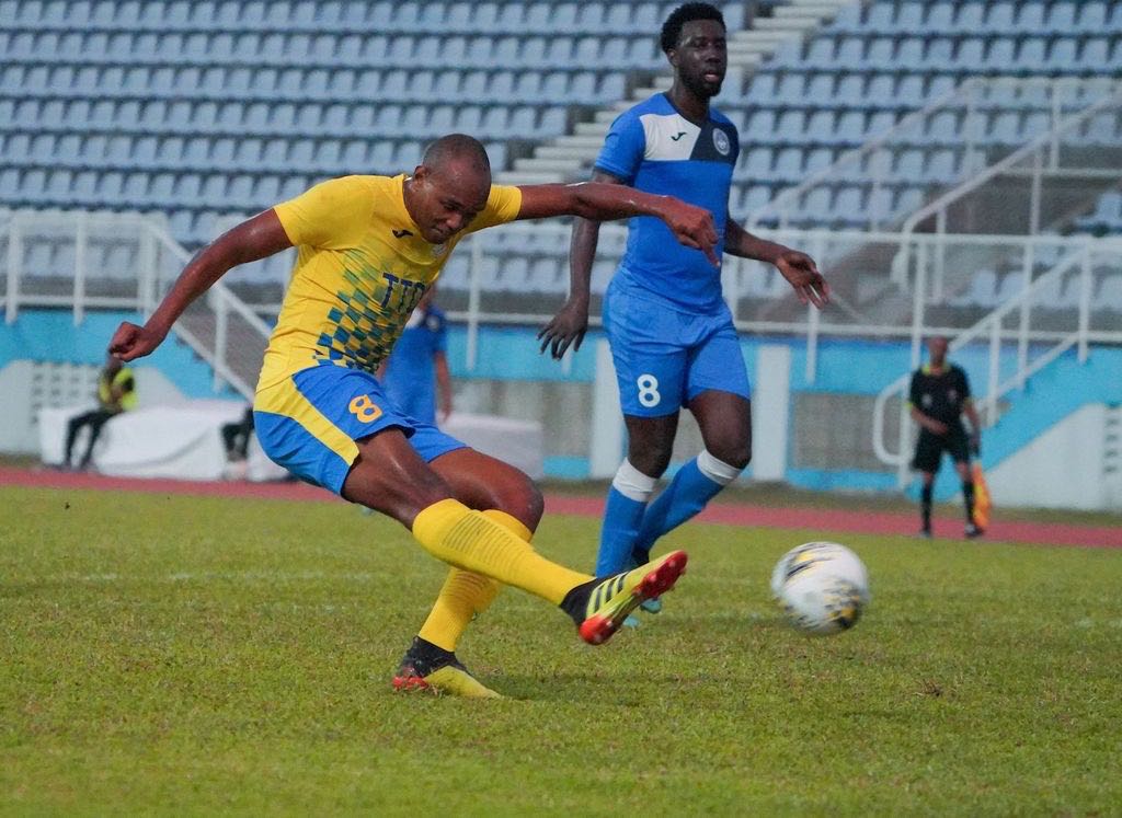 Defence Force Brent Sam, left, hits a shot at goal during the TT Pro League match between Defence Force and Police FC at Ato Boldon Stadium in Balmain, Couva on Sunday. Sam scored two goals to see Defence Force FC get passed Police FC 4-1.  Daniel Prentice/CA-images