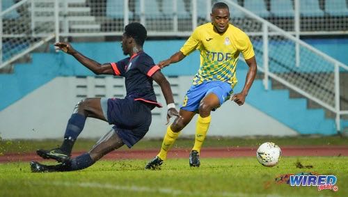 Photo: Defence Force attacker Reon Moore (left) dribbles past AC PoS defender Jokiah Leacock during Pro League action at the Ato Boldon Stadium on 14 February 2020. (Copyright Daniel Prentice/Wired868)