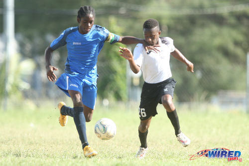 Photo: The Uprising Youths captain (left) tries to hold off a Crown Trace FC attacker during the 2015 Republic Bank National Youth Cup quarterfinals. ....(Courtesy Allan V Crane/Wired868)