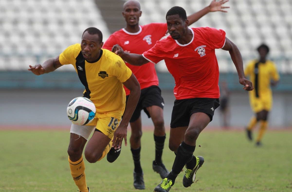 Cunupia FC striker Kevon Woodley, left, on the attack against Club Sando at the Larry Gomes Stadium, Arima, recently.