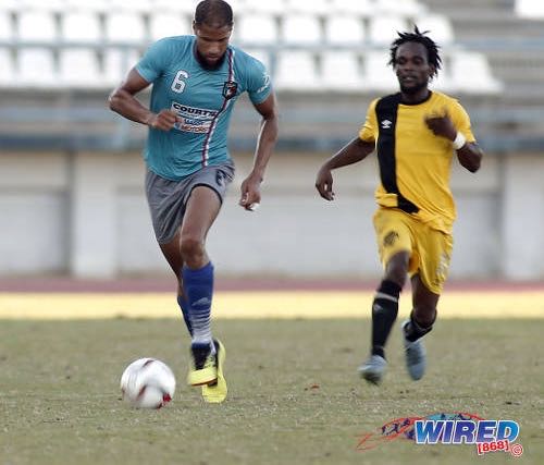 Photo: Morvant Caledonia AIA defender Radanfah Abu Bakr (left) advances with the ball while Cunupia FC flanker Hakeem Legall watches on during Ascension action at the Larry Gomes Stadium on 14 September 2019. (Copyright Annalicia Caruth/Wired868)