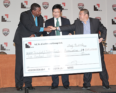 Chinese Ambassador to T&T Huang Xingyuan, centre, looks on as TTFA president David John Williams, left, receives a cheque from Michael Zhang, managing director of the SCG (Caribbean) Group Limited during the launch of company's sponsorship of the men's national football team at Hyatt Regency, Port-of-Spain, yesterday. Photo: MARCUS GONZALES