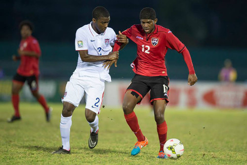 Photo: Trinidad and Tobago winger Kishun Seecharan (right) is kept in grip by United States right back Shaquell Moore. Moore is the child of Trinidad and Tobago immigrants to the United States. ...(Courtesy CONCACAF)