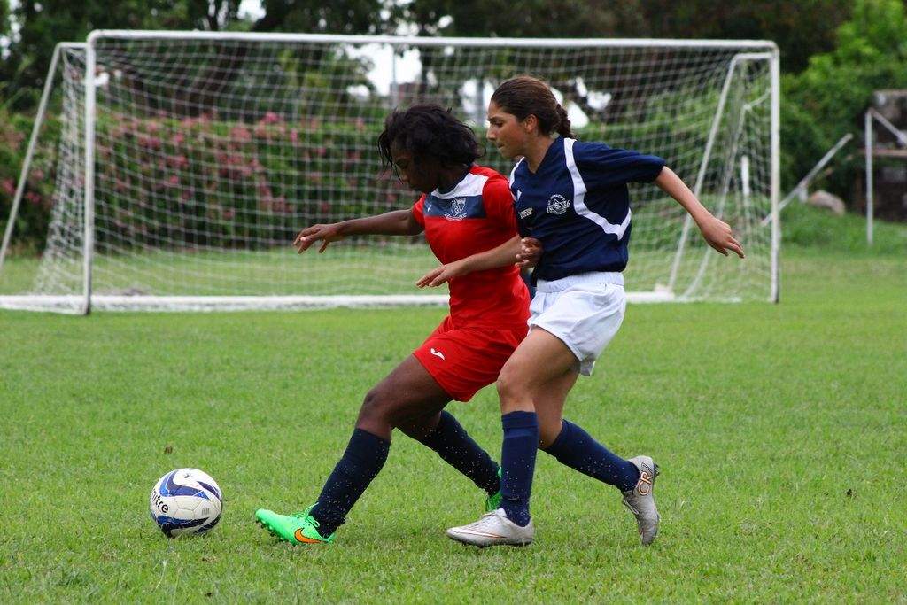 CLOSE QUARTERS: The girls Secondary Schools Football League has moved on to the Big Four competition. The zonal action produced a lot of goals like the 8-0 whipping handed out by Success Laventille (in red) against St Joseph’s Convent, Port of Spain. —Photo courtesy Nicholas Williams.