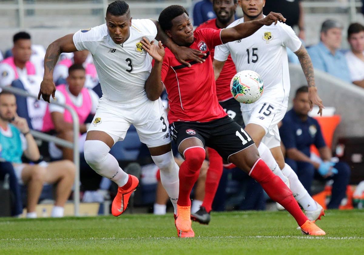 Trinidad and Tobago’s Levi Garcia (#11) battles for the ball with Panama’s Harold Cummings (left) during the first half of Tuesday’s match. (AP PHOTO)