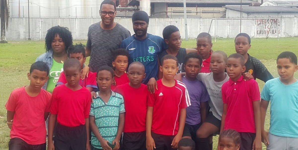 Former national player Shaka Hislop (second left, back row) poses with T&T Maestors players and their coach Sheldon DeFreitas (back centre) as well as youth football organiser Nekeisha (back left).