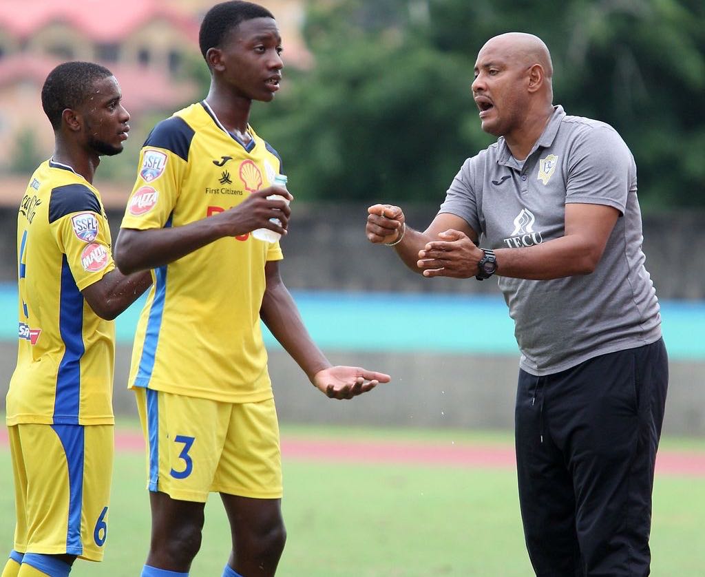 Shawn Cooper, right, the head coach of Presentation College of San Fernando gives instruction to his players Luke Charles, centre, and Zion Allen during their SSFL Premiership Division match at the Ato Boldon Stadium in Balmain, Couva on October 9. Presentation won 1-0.  ANTHONY HARRIS