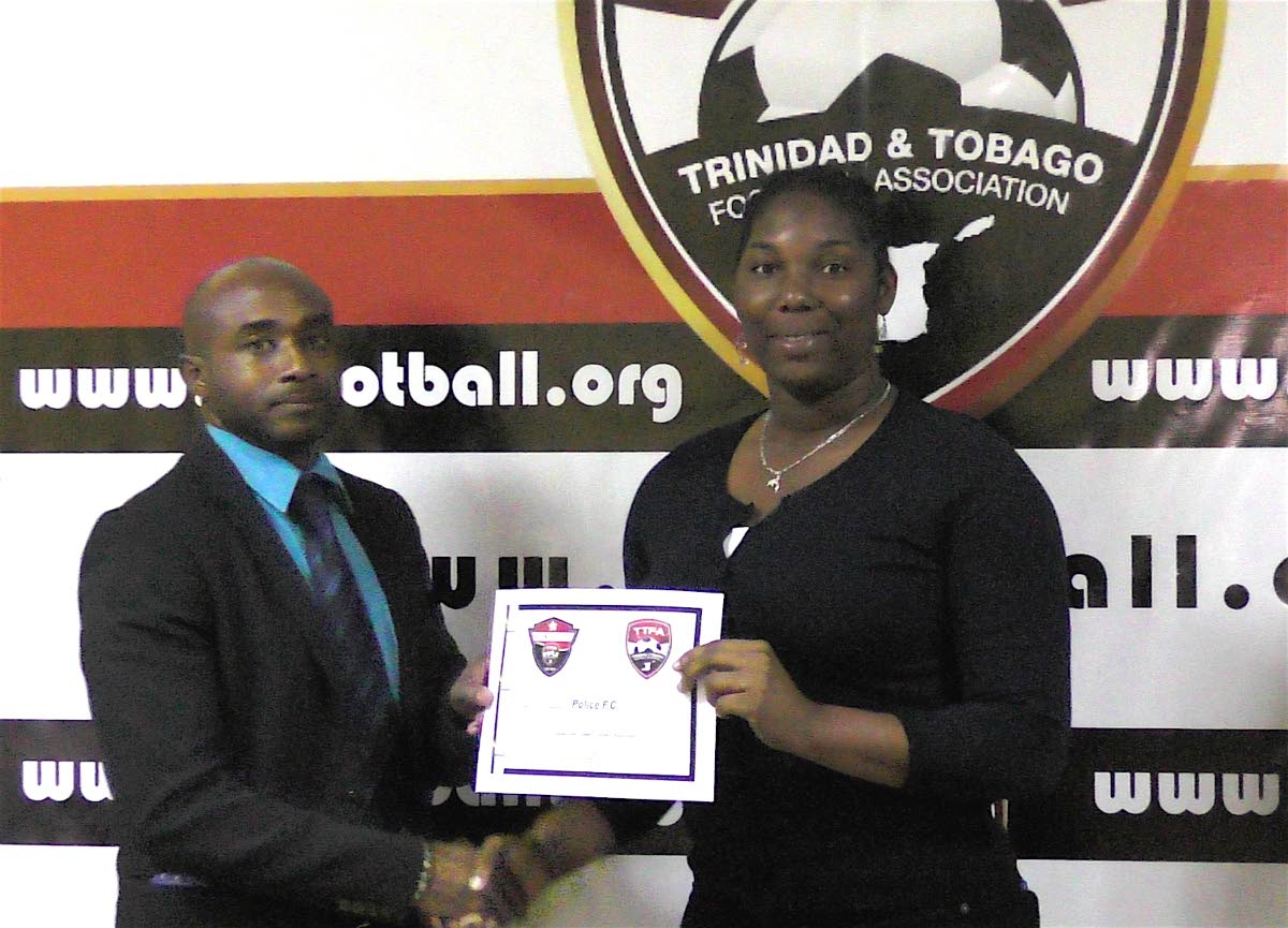 Christophe Braithwate, left, presents a club licensing certificate to a member of the Police FC management team.