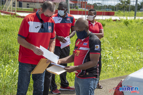 Photo: Trinidad and Tobago National U-15 assistant coach Wayne Sheppard (right) invites Soca Warriors head coach Terry Fenwick to sign up for the coaches association. (Copyright Ghansham Mohammed/GhanShyam Photography/Wired868)