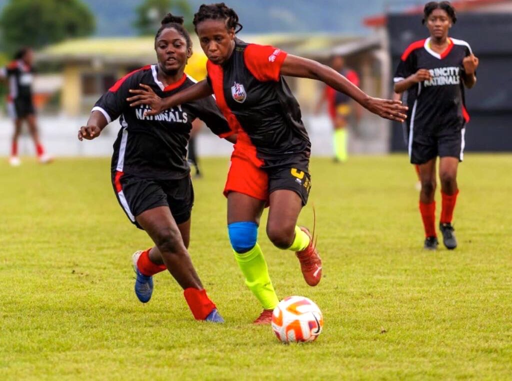 AC PoS's Naomie Guerra, centre, screens the ball from her Trincity Nationals rival in the Women's League Football semis at the Diego Martin Sporting Complex on Sunday. - WoLF