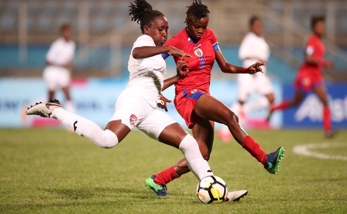Haitian defender heads the ball away from TT midfielder Shenieka Paul during the two Caribbean nations' opening match in the 2018 CONCACAF U20 Women's Championships at the Ato Boldon Stadium yesterday.