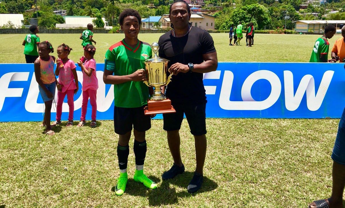 Jaheim Faustin, left, San Juan Jabloteh Under-14 forward and 2018 Flow Youth Pro League Golden Boot winner (12 goals), and his father, former T&T standout Marvin Faustin, pose with the 2018 FYPL U14 trophy at San Juan North Secondary on April 22.