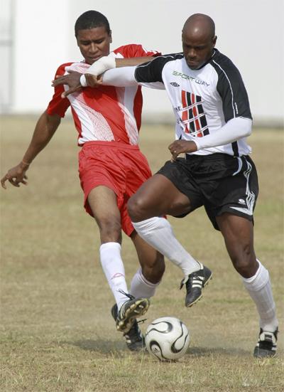 ﻿Derek Cave of Unit Trust, left, and Leonson Lewis of the Strike Squad battle for the ball during the launch of the Strike Squad's relief effort for Haiti labelled ‘Haiti You Are Not Forgotten’ on Saturday on Fatima grounds, Mucurapo.Photo: Anthony Harris
