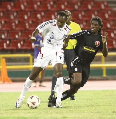 Kareem Joseph (left) of Caledonia AIA is confronted by Ma Pau's Elton John in Friday's Pro League match of the Hasley Crawford Stadium, Mucurapo. ...Author: ROGER JACOB (T&T Newsday).