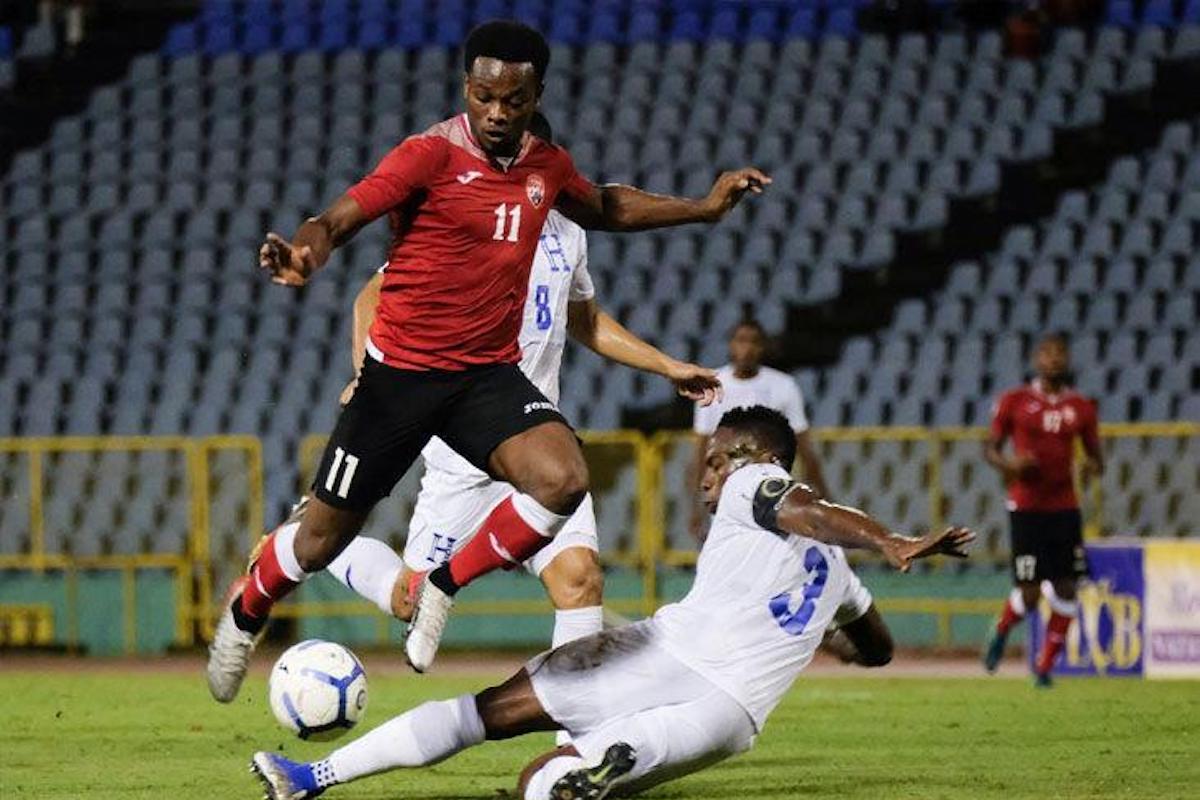 Trinidad and Tobago's Levi Garcia skips over a tackle from Honduras' Maynor Figueroa during a Concacaf Nations League match at Hasely Crawford Stadium, Mucurapo on October 10th 2019.