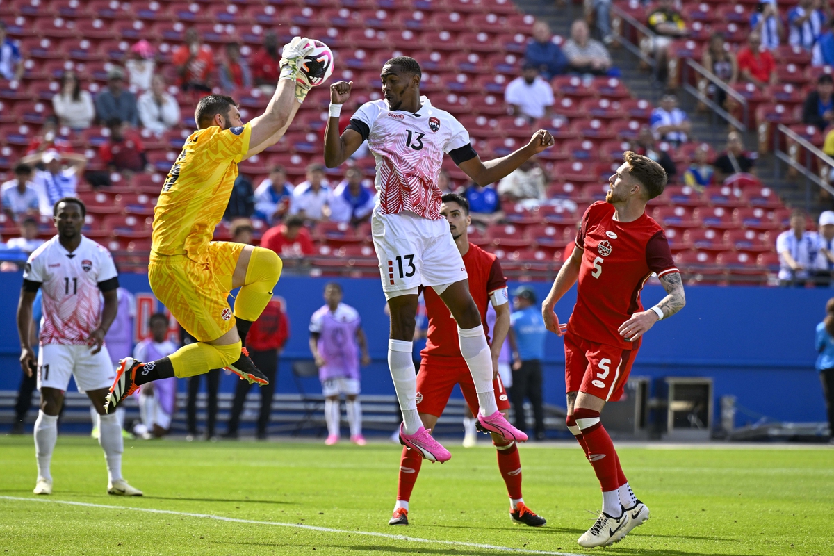 Mar 23, 2024; Frisco, Texas, USA; Canada goalkeeper Maxime Crepeau (16) makes a save in front of Trinidad and Tobago midfielder Reon Moore (13) as defender Joel Waterman (5) looks on during the second half at Toyota Stadium. Mandatory Credit: Jerome Miron-USA TODAY Sports