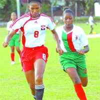 WOMEN PLAY: National Under-17 midfielder Victoria Swift, left, is pursued by Tunapuna Titans defenders Kalystra Diaz. The national under -17 women won the National Women's Super League match 5-0 on two Saturdays ago at Barataria Oval. —Photo: Anisto Alves
